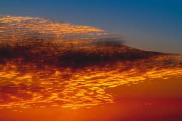 Sunny shine on clouds. Wonderful vivid dawn. Beautiful calm orange sunset. Scenic surreal sunrise. Amazing scenery of red blue cloudy sky. Picturesque sundown. Atmospheric cloudscape. Background.