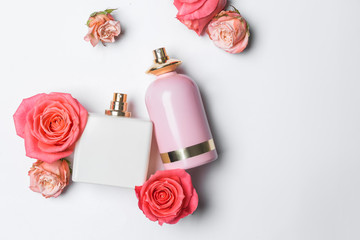 Bottles of perfume and flowers on white background - obrazy, fototapety, plakaty