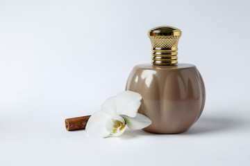 Bottle of perfume, flower and cinnamon on white background