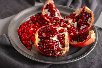 Plate with ripe pomegranate on table