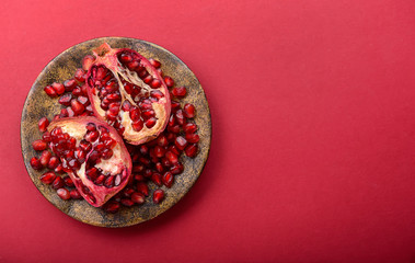Fototapeta na wymiar Plate with ripe pomegranates on color background