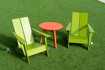 Decorative wooden chairs and table on the bright green lawn