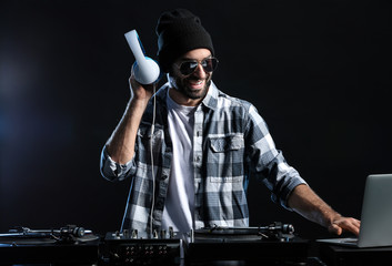 Male DJ playing music on dark background