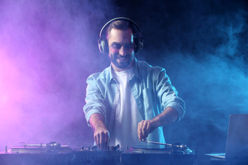 Male DJ playing music in club - obrazy, fototapety, plakaty