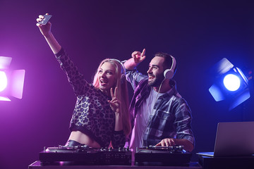 Cool DJs taking selfie in club