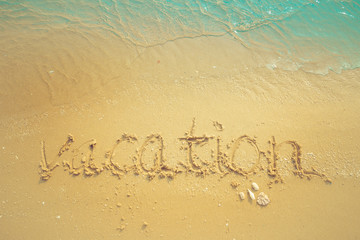 Vacation on the sand beach concept. Vacation Time words written into the sand on the beach at Rayong, Thailand