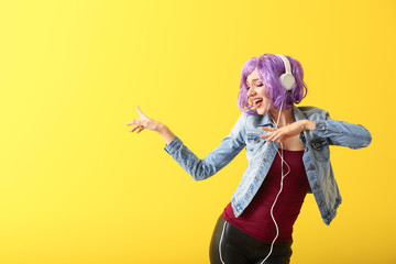 Beautiful young woman with headphones dancing against color background - Powered by Adobe