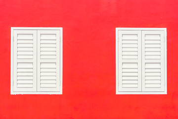 Simple duotone white closed window and bright red wall of building exterior flat facade with space for text