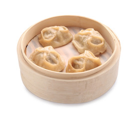 Bamboo steamer with tasty dumplings on white background