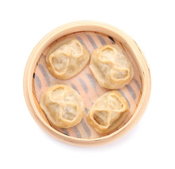 Bamboo steamer with tasty dumplings on white background