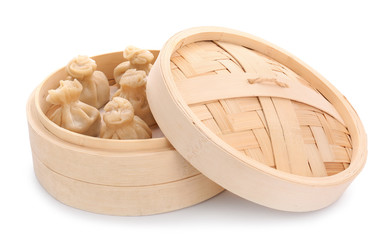 Bamboo steamer with tasty dumplings on white background