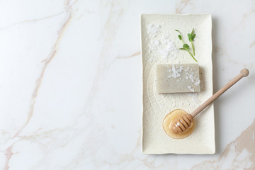 Natural soap, sea salt and honey for skin care on light background