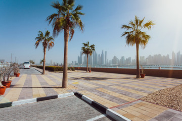 Dubai, United Arab Emirates - June, 2018. Buildings, street, sunny day, palm trees. Skyscrapers at Dubai Marina Promenade