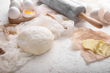 Dough and ingredients for making bread on table