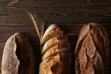 Different fresh bread on wooden background