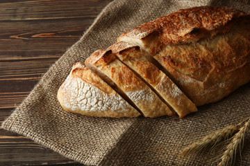 Cut fresh bread on wooden background