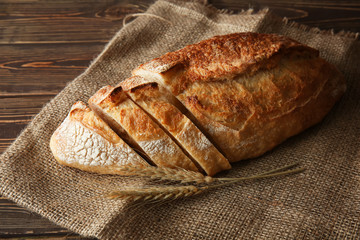 Cut fresh bread on wooden background