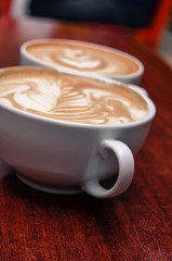 Two hot Cappuccino coffee on wooden table