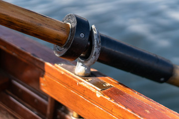 Closeup photo of wooden paddle attached to boat used for rowing in the water, lake Bled on a sunny day