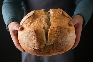 Man with loaf of fresh bread, closeup