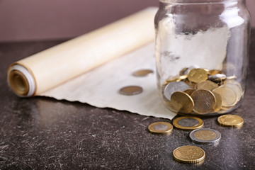 The Scroll of Esther and jar with coins on table. Purim celebration