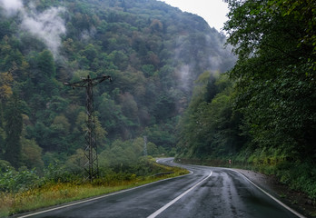 High mountain road is being covered with fog.