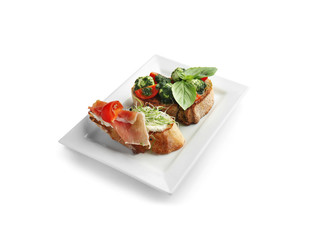 Plate with fresh tasty bruschettas on white background