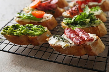 Fresh tasty bruschettas on cooling rack, closeup