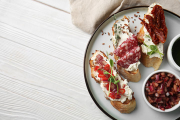 Plate with fresh tasty bruschettas on wooden background