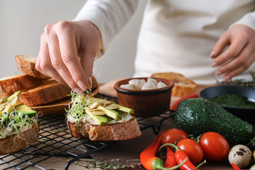 Woman preparing tasty bruschettas in kitchen, closeup