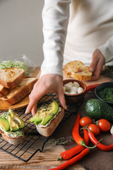 Woman preparing tasty bruschettas in kitchen