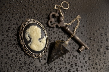 old rusty key with dark crystal and brooch 