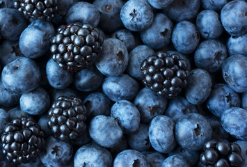 Texture berries close up. Top view. Black and blue berries. Ripe blueberries and blackberries. Various fresh summer berries.