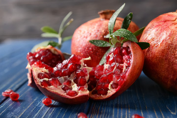 Ripe pomegranates on color wooden table