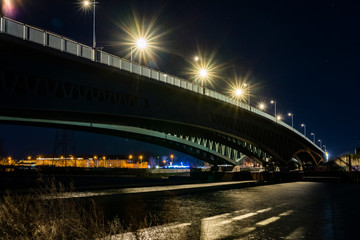 Under a large bridge at night, a massive bridge construction at night, minna todenhagen bridge at night