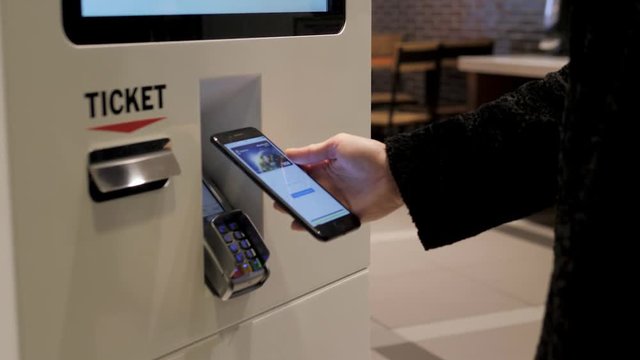 Woman customer store place orders and pay by contactless credit card mobile phone through self pay floor fast food, payment terminal touchscreen big cafe. Paypass.