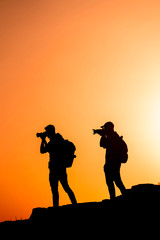 Photographers who shoots a sunset in the mountains