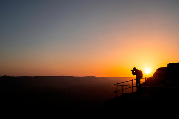 Naklejka premium Photographer who shoots a sunset in the mountains