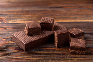 Chocolate toffees on dark wooden background.