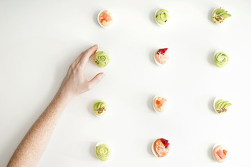 Female hand and tasty deviled eggs on white background