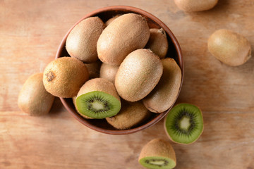 Bowl with tasty kiwi on table