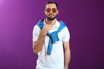 Handsome fashionable man on color background