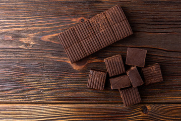 Chocolate toffees on dark wooden background.