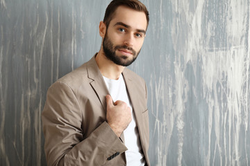 Handsome fashionable man near grunge wall