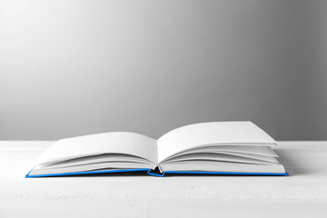 Open book on table against grey background