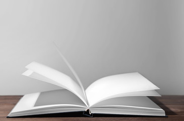 Open book on table against grey background