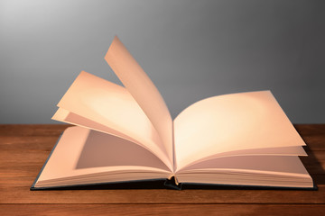 Open book on table against grey background