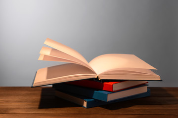 Open books on table against grey background