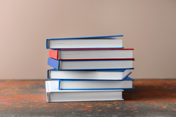 Many books on table against color background