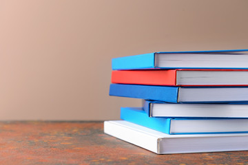 Many books on table against color background